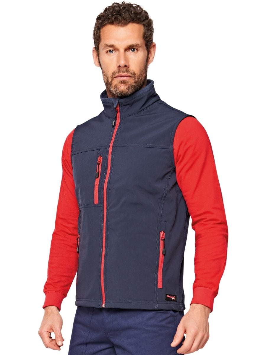 Marineblaue Softshell-Weste am Modell mit Stehkragen und roten Akzenten vorn.