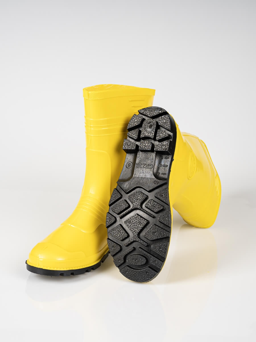 Gelber Gummistiefel mit geöffneter Innensohle und schwarzem Außensohlenprofil