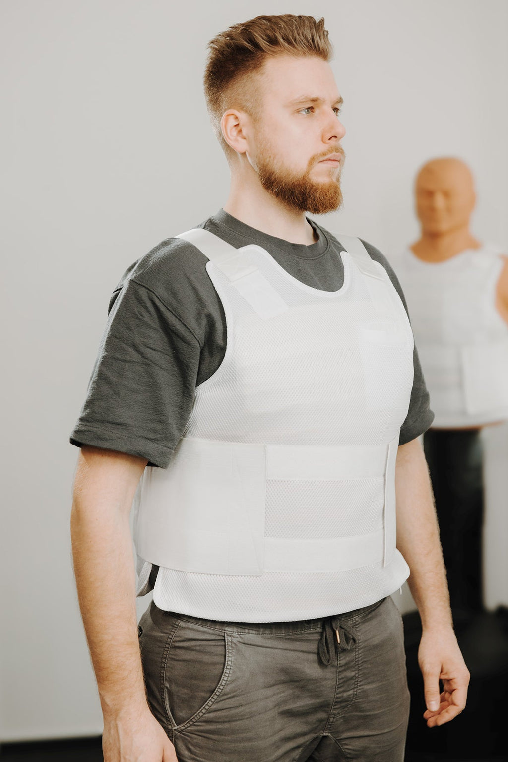 Stichschutzweste weiß über T‑Shirt, Schulterpartie und Frontpanel deutlich sichtbar