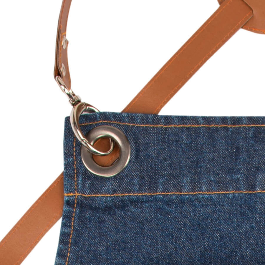 Jeans-Schürze mit braunen Lederträgern und großen Metallösen zur Befestigung